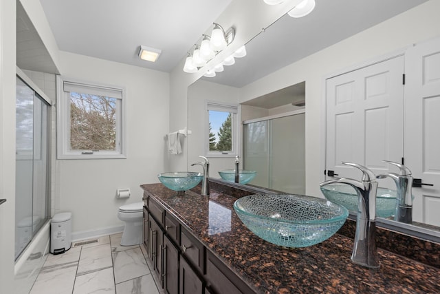 full bathroom with a wealth of natural light, visible vents, a sink, and toilet