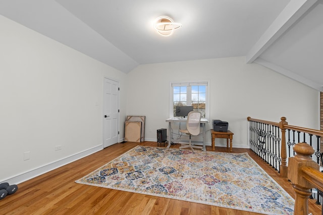 interior space with baseboards, wood finished floors, and lofted ceiling