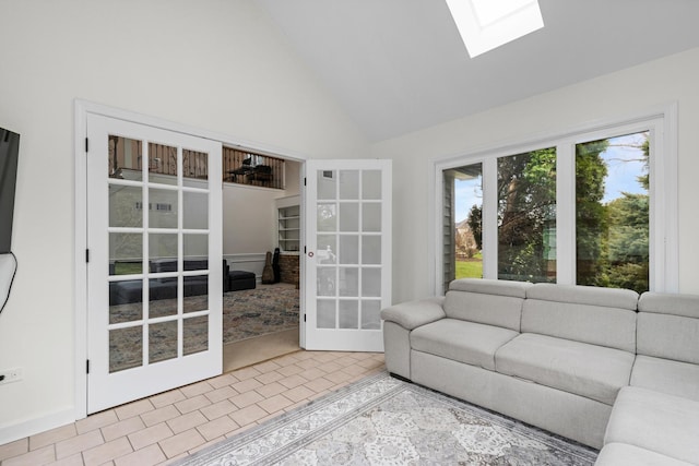 living area with french doors, a skylight, and high vaulted ceiling