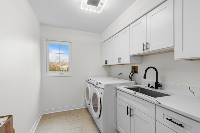 laundry area with light tile patterned floors, cabinet space, a sink, baseboards, and washing machine and dryer