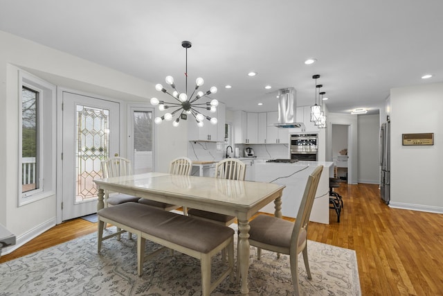 dining area featuring baseboards, recessed lighting, a chandelier, and light wood finished floors