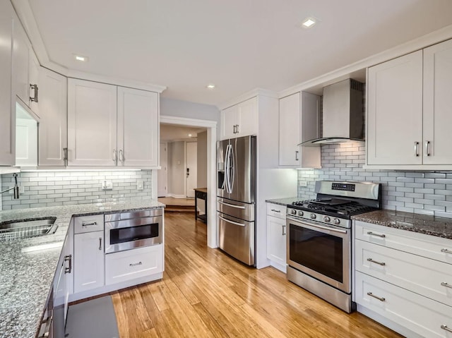 9748 Mill Dr E Unit 2E, Palos Park, IL 60464 - kitchen featuring stainless steel appliances, wall chimney exhaust hood, a sink, white cabinetry, and dark stone counters