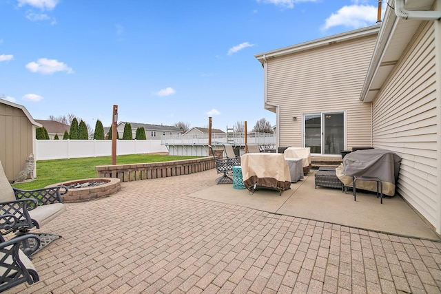 view of patio / terrace with an outdoor living space with a fire pit, a fenced backyard, and grilling area