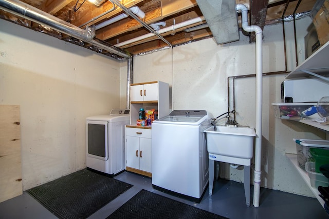 washroom featuring independent washer and dryer, a sink, and cabinet space