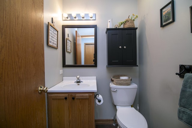 half bathroom featuring vanity and toilet