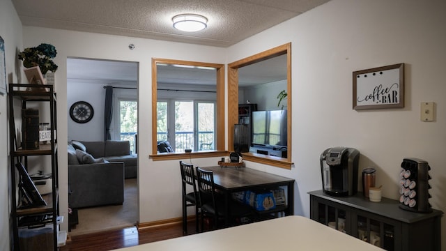 dining room with baseboards, a textured ceiling, and wood finished floors