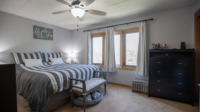 bedroom featuring a textured ceiling, ceiling fan, light carpet, and baseboards