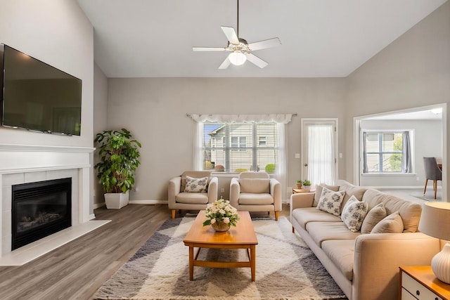 living room featuring a ceiling fan, baseboards, a wealth of natural light, and light wood-style floors