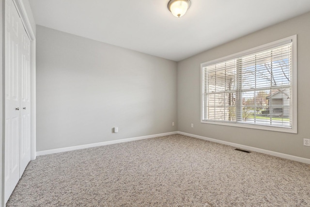 unfurnished room featuring visible vents, baseboards, and carpet floors