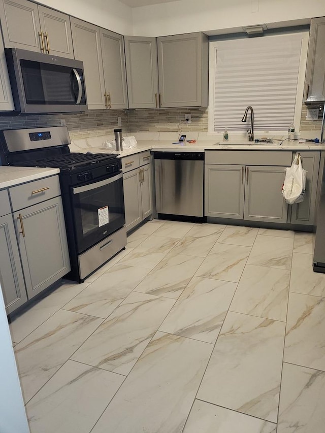 579 Price Ave, Calumet City, IL 60409 - kitchen featuring stainless steel appliances, gray cabinets, a sink, light marble finish floors, and light countertops