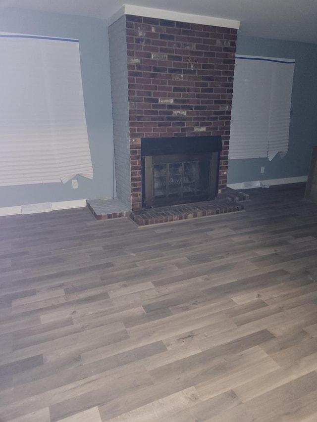 579 Price Ave, Calumet City, IL 60409 - unfurnished living room featuring wood finished floors, a brick fireplace, and baseboards