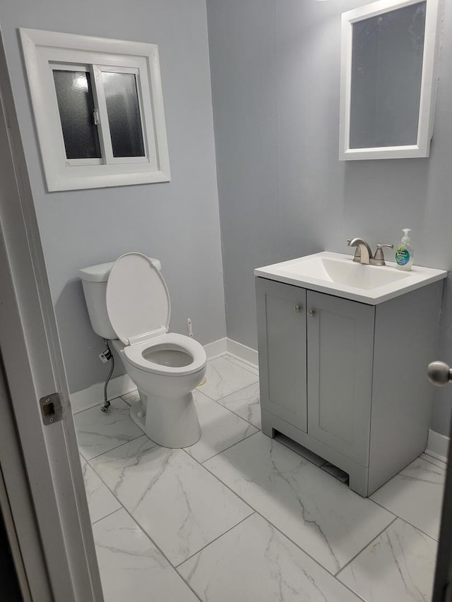 579 Price Ave, Calumet City, IL 60409 - half bathroom featuring marble look tile flooring, baseboards, vanity, and toilet