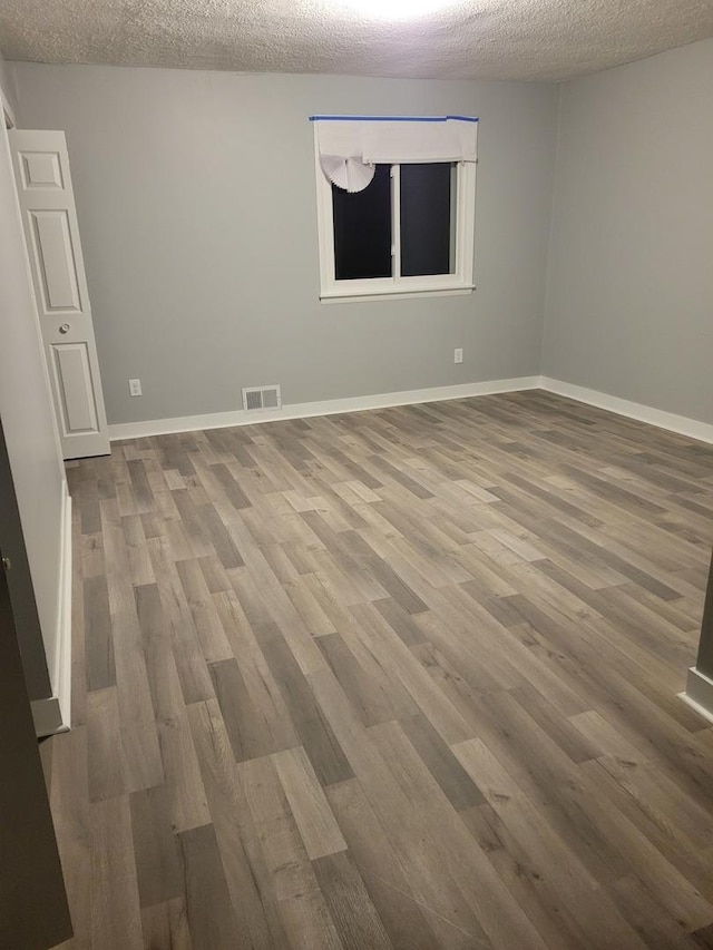579 Price Ave, Calumet City, IL 60409 - unfurnished room featuring wood finished floors, a textured ceiling, and baseboards