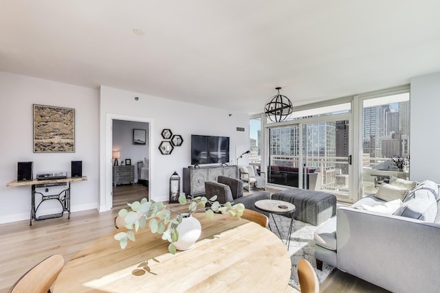 living area featuring baseboards, an inviting chandelier, and wood finished floors