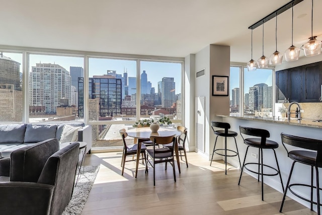 dining space with visible vents, a city view, and light wood-style flooring