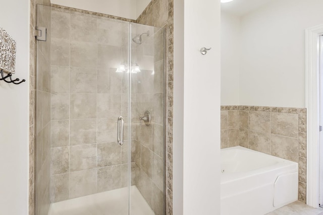bathroom featuring a garden tub and a stall shower