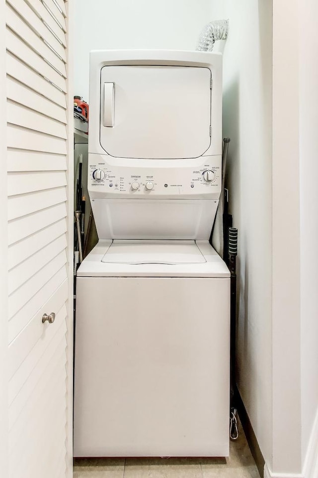 clothes washing area with stacked washer / drying machine and laundry area