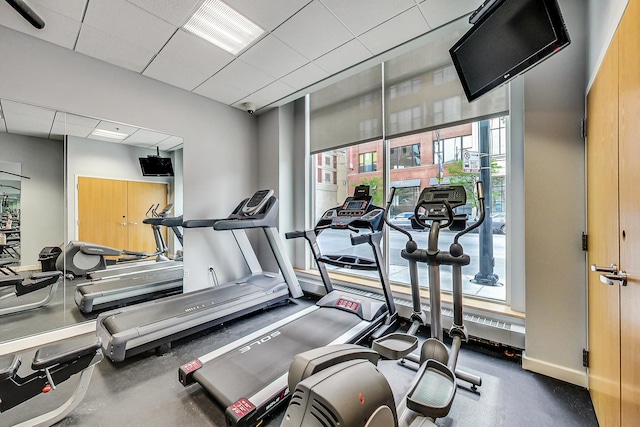 workout area with baseboards and a paneled ceiling