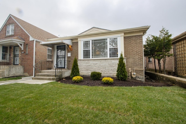 view of front of home featuring stone siding, a front lawn, and brick siding
