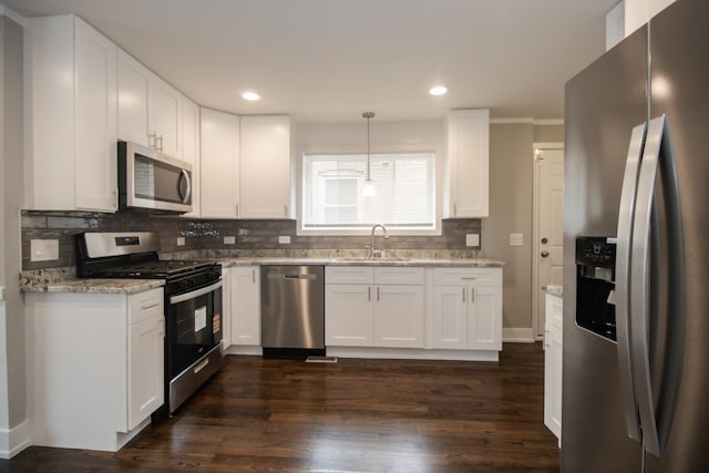 kitchen with a sink, decorative backsplash, white cabinets, and stainless steel appliances