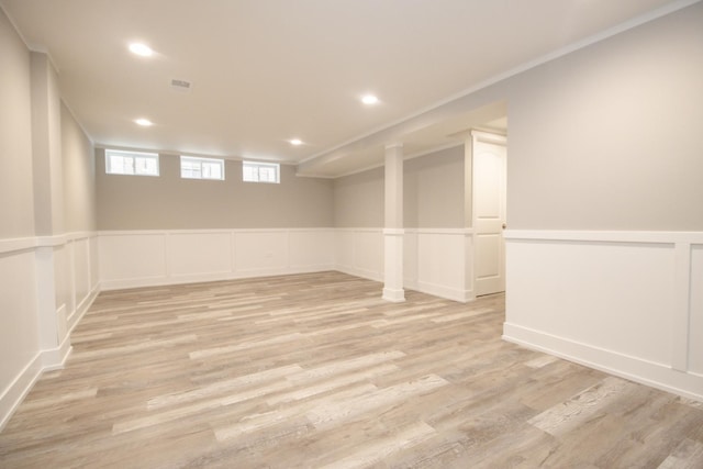 below grade area featuring recessed lighting, light wood-style flooring, a wainscoted wall, visible vents, and a decorative wall