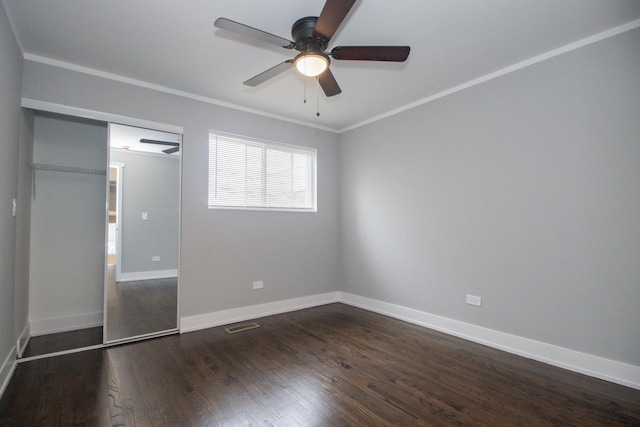 unfurnished bedroom with baseboards, ornamental molding, a ceiling fan, visible vents, and dark wood finished floors