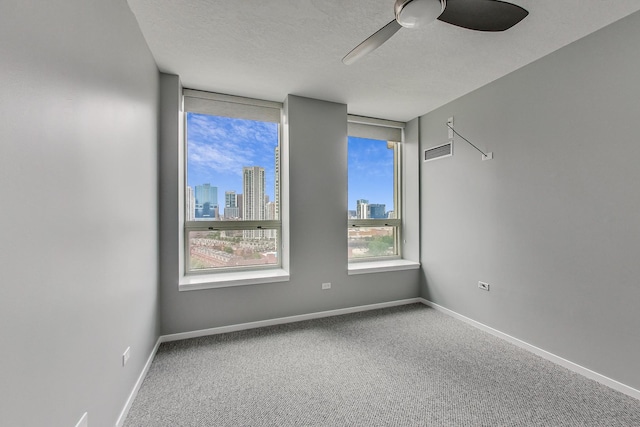 600 N Kingsbury St Unit 1612, Chicago, IL 60654 - carpeted empty room with a textured ceiling, visible vents, baseboards, a city view, and a ceiling fan