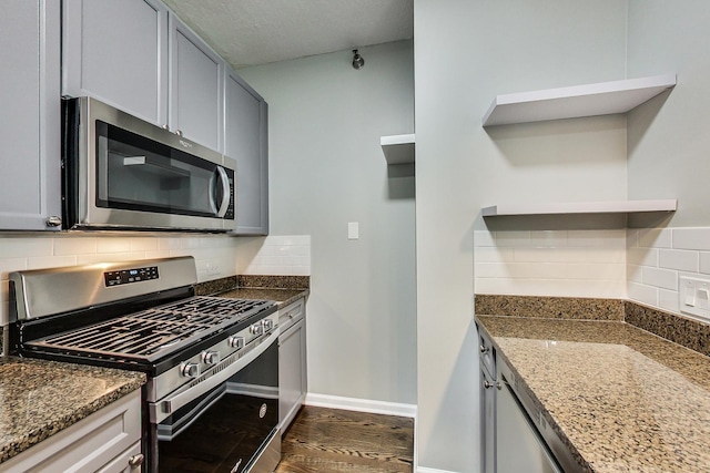 600 N Kingsbury St Unit 1612, Chicago, IL 60654 - kitchen featuring dark stone countertops, tasteful backsplash, open shelves, appliances with stainless steel finishes, and dark wood-style floors