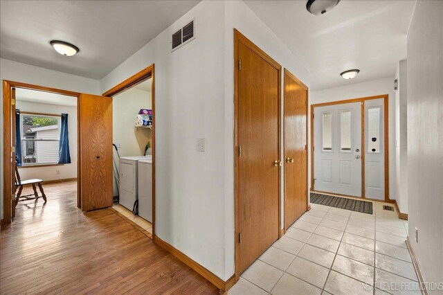 317 Plymouth Ct, Sycamore, IL 60178 - hallway with washing machine and clothes dryer, baseboards, and light wood-style floors
