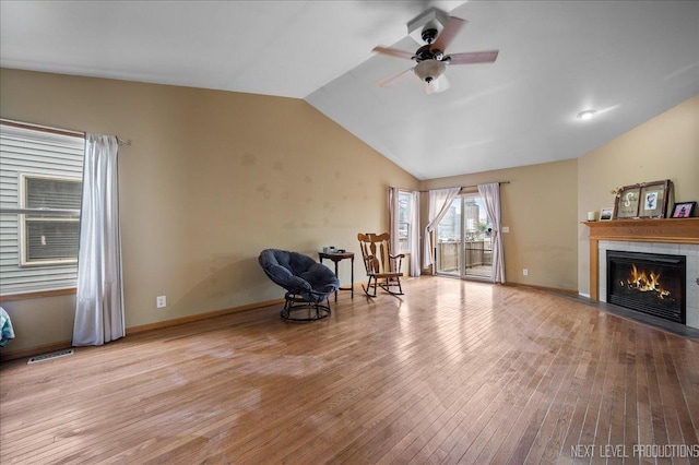 317 Plymouth Ct, Sycamore, IL 60178 - unfurnished room with wood finished floors, a ceiling fan, vaulted ceiling, a fireplace with flush hearth, and baseboards