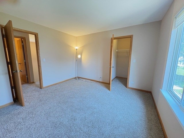 794 Meadowridge Dr, Aurora, IL 60504 - unfurnished bedroom featuring light carpet, a spacious closet, and a closet
