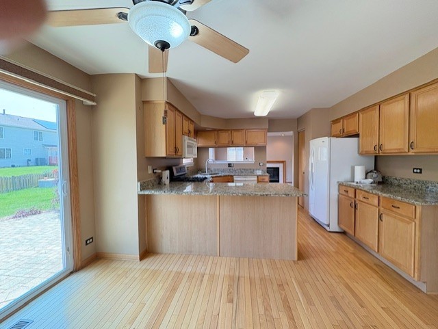 794 Meadowridge Dr, Aurora, IL 60504 - kitchen featuring white appliances, a ceiling fan, light wood-style flooring, a peninsula, and light stone countertops