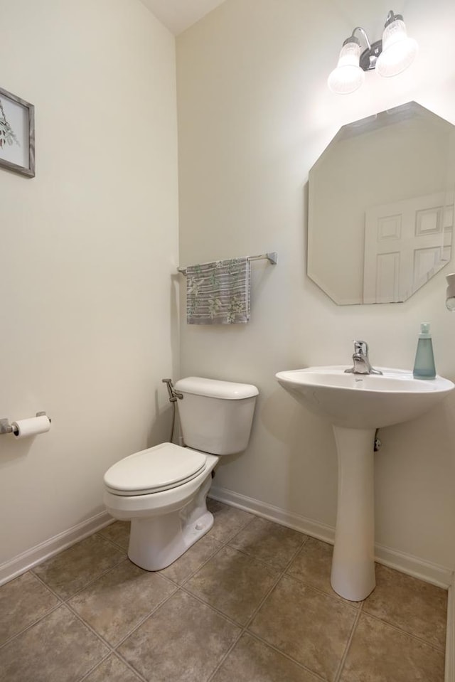 bathroom with toilet, tile patterned floors, and baseboards