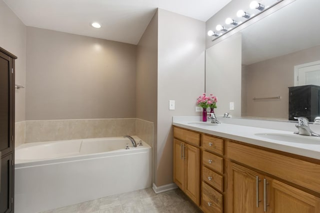 bathroom with double vanity, a garden tub, tile patterned floors, and a sink