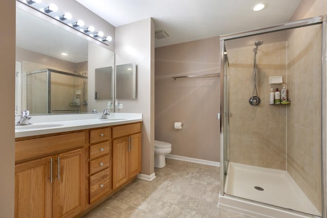 bathroom with toilet, double vanity, a sink, and a shower stall