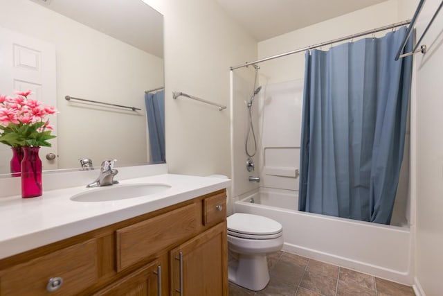 full bathroom featuring stone finish flooring, shower / bath combo with shower curtain, toilet, and vanity