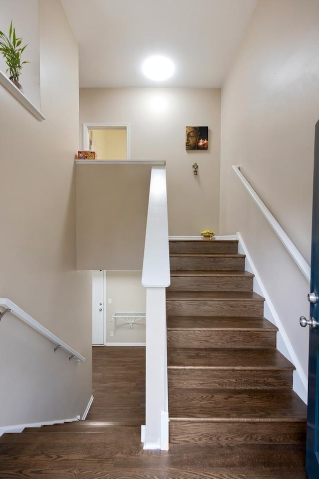 staircase with wood finished floors and baseboards
