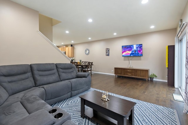 living room featuring baseboards, recessed lighting, stairs, and dark wood-type flooring