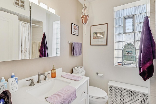full bath with vanity, curtained shower, toilet, visible vents, and radiator
