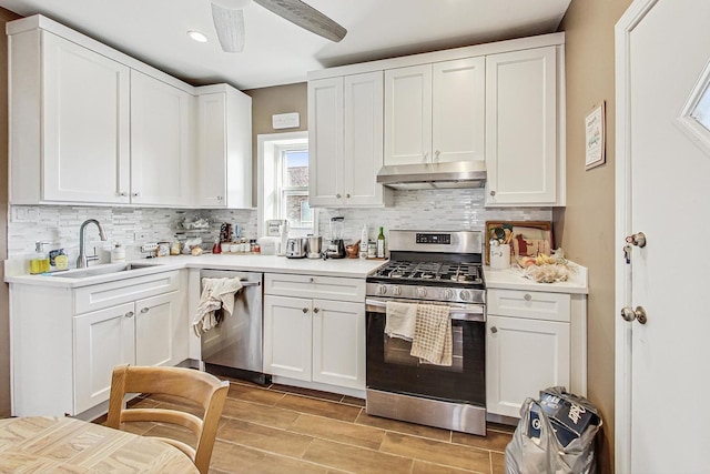 kitchen featuring a sink, appliances with stainless steel finishes, under cabinet range hood, recessed lighting, and decorative backsplash