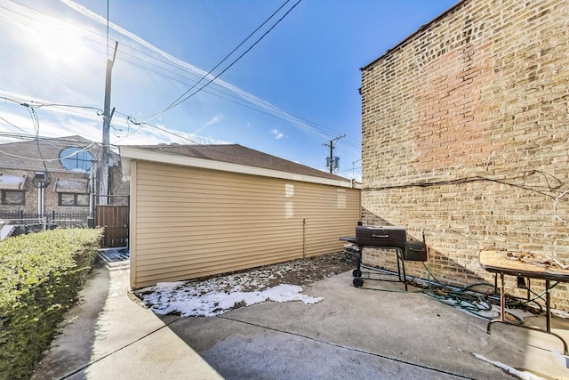 exterior space with a patio, an outbuilding, and fence