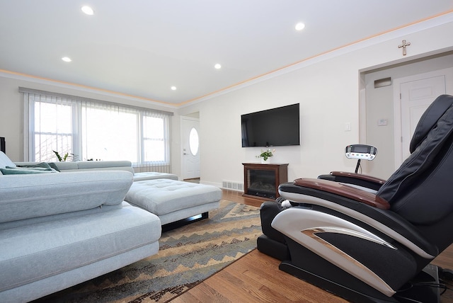 living area with visible vents, crown molding, wood finished floors, a fireplace, and recessed lighting