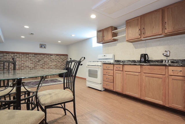 kitchen with open shelves, white gas range oven, light wood finished floors, backsplash, and visible vents