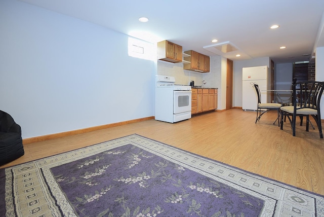 kitchen featuring light wood-style floors, baseboards, and white appliances