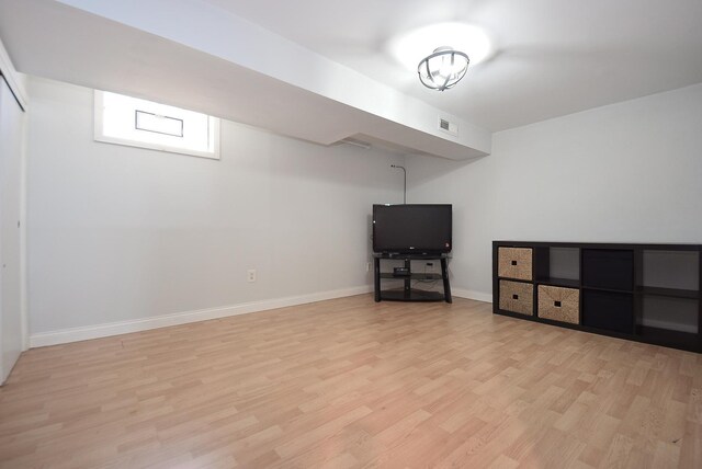 basement featuring visible vents, light wood finished floors, and baseboards