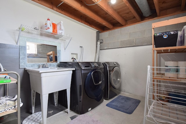 laundry room featuring concrete block wall, laundry area, and independent washer and dryer