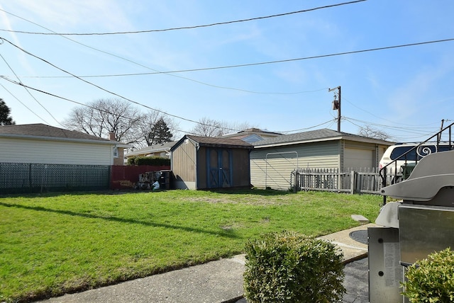 view of yard with a storage unit, fence, an outbuilding, and a garage