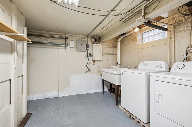 laundry area featuring washing machine and dryer, electric panel, laundry area, and a sink