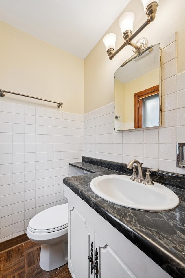 bathroom with tile walls, vanity, backsplash, and toilet