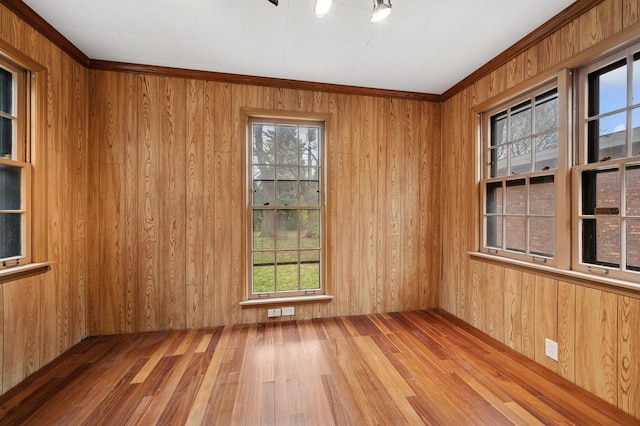 unfurnished room with wooden walls and hardwood / wood-style flooring